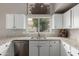 Bright kitchen features granite counters, stainless steel dishwasher and ample white cabinets at 6014 E Sayan Cir, Mesa, AZ 85215