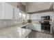 Well-lit kitchen featuring granite countertops, stainless steel appliances, and white cabinets at 6014 E Sayan Cir, Mesa, AZ 85215