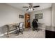 This home office features two desks, wood-look floors, a ceiling fan, and a bookcase at 6014 E Sayan Cir, Mesa, AZ 85215