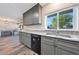 Bright kitchen area with granite counters and stainless steel sink under a window, blending functionality with style at 6029 W Pershing Ave, Glendale, AZ 85304