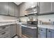 Close-up of a kitchen with stainless steel appliances, granite countertops, and grey cabinetry for a sleek design at 6029 W Pershing Ave, Glendale, AZ 85304