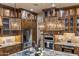 Gourmet kitchen featuring stainless appliances, decorative lighting, and custom cabinets with granite counters at 6888 E Mighty Saguaro Way, Scottsdale, AZ 85266