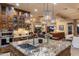 Gourmet kitchen featuring granite counters, stainless appliances, an island, and stone accents at 6888 E Mighty Saguaro Way, Scottsdale, AZ 85266