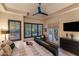 Bright main bedroom boasting a tray ceiling, outdoor access, and a large window with plantation shutters at 6888 E Mighty Saguaro Way, Scottsdale, AZ 85266