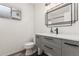 Modern bathroom features gray vanity with drawers, black hardware, and rectangular mirror at 7416 S Mcallister Ave, Tempe, AZ 85283