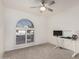Bright bedroom with white walls and carpet, ceiling fan, and arched shuttered window at 7416 S Mcallister Ave, Tempe, AZ 85283
