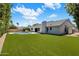 Expansive backyard featuring lush green lawn, sparkling pool, and outdoor kitchen for entertaining at 7528 E Windrose Dr, Scottsdale, AZ 85260