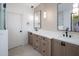 Bright bathroom featuring dual sinks, wood cabinets, white countertops, and modern lighting at 7528 E Windrose Dr, Scottsdale, AZ 85260