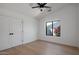Bedroom with hardwood floors, window with landscaping view, and a ceiling fan at 7528 E Windrose Dr, Scottsdale, AZ 85260