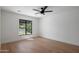 This bedroom offers great light with its large window and features wood flooring and a ceiling fan at 7528 E Windrose Dr, Scottsdale, AZ 85260