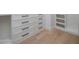 Walk-in closet with built-in dressers and wood floors at 7528 E Windrose Dr, Scottsdale, AZ 85260