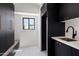 Well-lit laundry room features black cabinetry, white countertops, and stylish tile flooring at 7528 E Windrose Dr, Scottsdale, AZ 85260