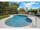 Backyard pool with a stainless steel ladder, lush landscaping and blue skies at 7528 E Windrose Dr, Scottsdale, AZ 85260