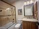 Bathroom featuring a tiled shower-tub combo, granite vanity, and a framed mirror for a functional yet elegant design at 8964 E Mountain Spring Rd, Scottsdale, AZ 85255