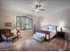 A well-lit main bedroom with a ceiling fan, shuttered windows, and light neutral walls on light-colored stone flooring at 8964 E Mountain Spring Rd, Scottsdale, AZ 85255