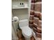 Bathroom with white toilet, shower with curtain and open storage shelves at 907 E Lancaster Cir, Florence, AZ 85132