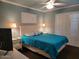 Bedroom with blue bedspread, ceiling fan, and white plantation shutters at 907 E Lancaster Cir, Florence, AZ 85132