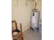 Water heater in storage space with chair at 907 E Lancaster Cir, Florence, AZ 85132