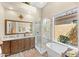 Spa-like bathroom featuring a soaking tub, a walk-in shower, and a dual sink vanity with great natural light at 9327 E Whitewing Dr, Scottsdale, AZ 85262