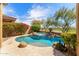 Backyard with a blue-tiled pool and spa featuring lush landscaping at 9327 E Whitewing Dr, Scottsdale, AZ 85262