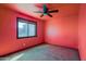 Bedroom featuring a ceiling fan, and a window with outside view and a red accent wall at 9541 W Frank Ave, Peoria, AZ 85382