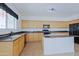 Kitchen features wooden cabinets, granite countertops, tile flooring, and black appliances at 9541 W Frank Ave, Peoria, AZ 85382