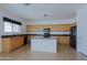Open kitchen layout with an island, tile flooring, wood cabinets, and black appliances at 9541 W Frank Ave, Peoria, AZ 85382