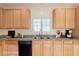 Well-lit kitchen features granite countertops, a stainless steel sink, and wood cabinets for a bright, welcoming atmosphere at 10325 W Sands Dr # 456, Peoria, AZ 85383