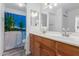 Bathroom features double sinks, a tropical themed shower curtain, and ample lighting at 17808 N 45Th Ave, Glendale, AZ 85308