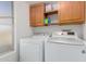 Bright laundry area featuring side-by-side washer and dryer with shelving and ample lighting at 17808 N 45Th Ave, Glendale, AZ 85308
