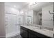 Bathroom showcasing double sink vanity with granite countertops and a glass-enclosed shower at 18220 W Daley Ln, Surprise, AZ 85387
