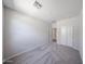 A bright bedroom with plush carpeting, showcasing a closet with sliding doors and abundant space at 18220 W Daley Ln, Surprise, AZ 85387
