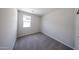 A bright bedroom featuring a window and neutral carpet, offering a serene and adaptable space at 18220 W Daley Ln, Surprise, AZ 85387