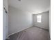 A clean, carpeted bedroom with a window offering natural light and a closet with sliding doors at 18220 W Daley Ln, Surprise, AZ 85387