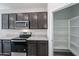 Modern kitchen featuring stainless steel appliances, granite countertops and a convenient pantry at 18220 W Daley Ln, Surprise, AZ 85387