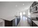 Bright kitchen featuring an island with granite countertops, sleek appliances, and an open floor plan at 18220 W Daley Ln, Surprise, AZ 85387