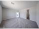 Large main bedroom features neutral carpet, access to en-suite bathroom, and lots of light at 18220 W Daley Ln, Surprise, AZ 85387