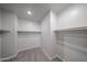 Spacious walk-in closet with ample storage space, shelving, and carpet at 18220 W Daley Ln, Surprise, AZ 85387