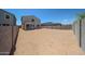 Spacious dirt backyard surrounded by block fence, complemented by a covered patio at 18244 W Daley Ln, Surprise, AZ 85387