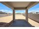View of the spacious, dirt backyard and covered patio with block fence, ready for customization at 18244 W Daley Ln, Surprise, AZ 85387