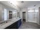 Bathroom featuring a double sink vanity with granite counters, tiled floors, and glass shower enclosure at 18244 W Daley Ln, Surprise, AZ 85387