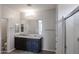 Bathroom featuring a vanity with granite counters, dark cabinets, and glass shower enclosure at 18244 W Daley Ln, Surprise, AZ 85387