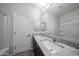 Bright bathroom features a double sink vanity with a white counter and wood-look floors at 18244 W Daley Ln, Surprise, AZ 85387