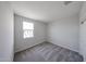 Neutral bedroom with gray carpet, a bright window, and a closet with white doors at 18244 W Daley Ln, Surprise, AZ 85387