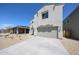 Side view of a modern two-story home featuring a two-car garage and minimal landscaping at 18244 W Daley Ln, Surprise, AZ 85387