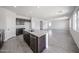 Open-concept kitchen showcasing a center island with sink, dishwasher, and granite countertop at 18244 W Daley Ln, Surprise, AZ 85387
