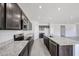 Modern kitchen featuring granite countertops, stainless steel appliances, and dark wood cabinetry at 18244 W Daley Ln, Surprise, AZ 85387