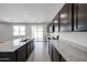 Bright kitchen with granite countertops, center island, stainless appliances, and access to the patio at 18244 W Daley Ln, Surprise, AZ 85387