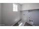 Functional laundry room features a shelf, window, and includes washer/dryer hookups at 18244 W Daley Ln, Surprise, AZ 85387