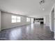 Spacious living room with tile flooring, large windows, and open concept design to kitchen at 18244 W Daley Ln, Surprise, AZ 85387